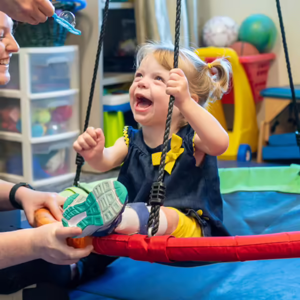 girl on therapy swing wearing leg braces