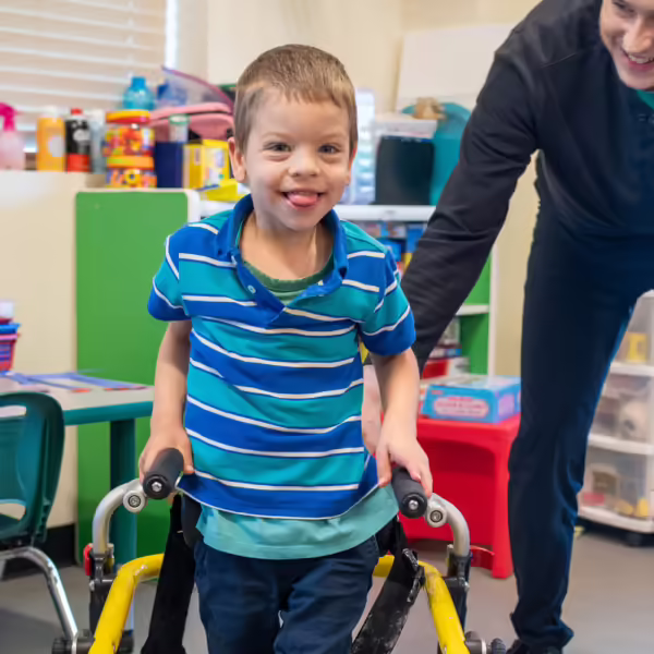 boy using walking assistance smiling